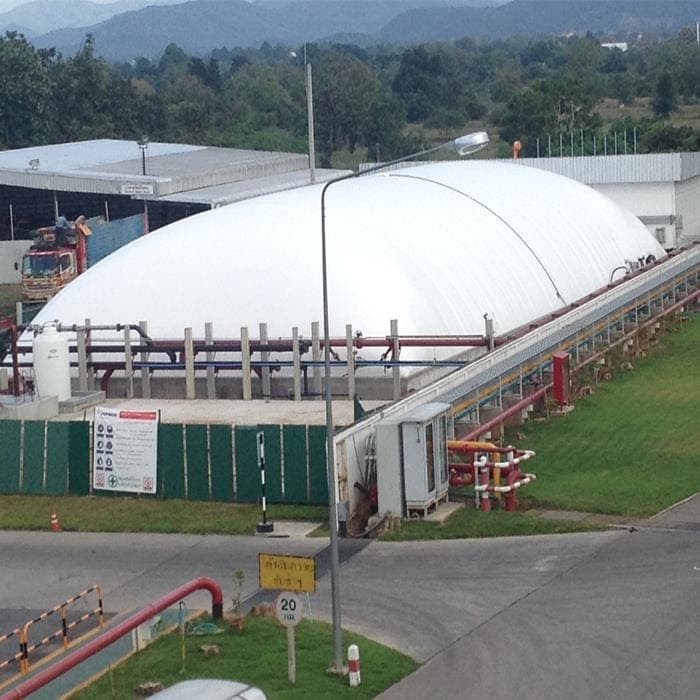 An elongated white membrane cover above a rectangular structure, with surrounding pipes and access routes.