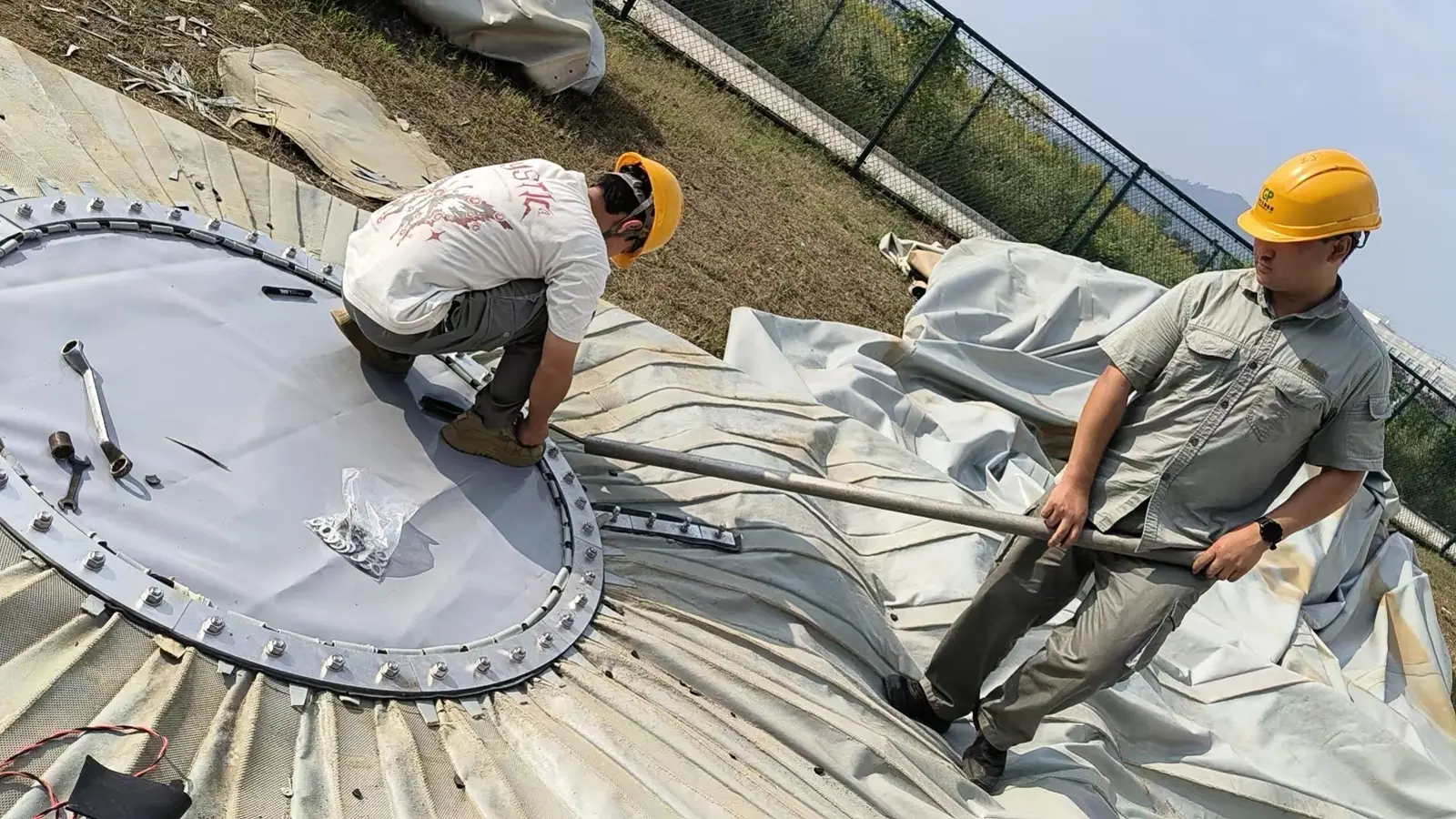 地面作业区内，人员配合处理圆形顶板与周边连接件。
